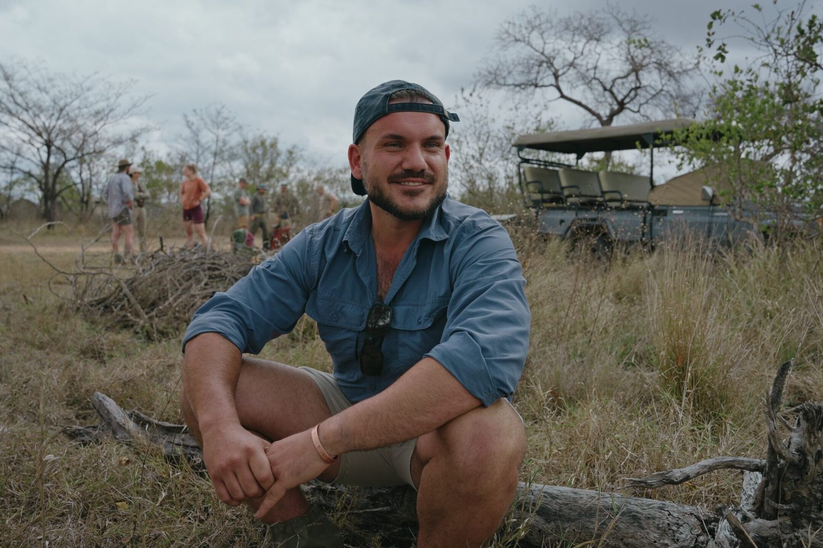Deelnemer Ruan vertelt in een interview over zichzelf en waar hij naar uitkijkt tijdens de Primitive Trail, met de safariwagen en andere deelnemers op de achtergrond.